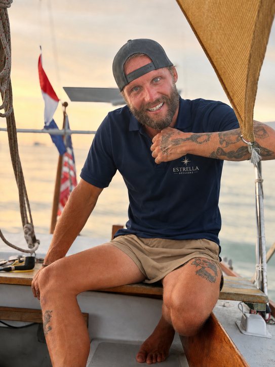 Dillon Robbins sitting on the deck of Estrella at sunset